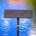 Recirculated water sign on reflective blue water Royalty Free Stock Photo