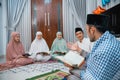 Recitation leader gives explanation while reading the Holy Quran