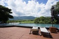 Recliner chairs on the deck next to swiming pool with green mountian background Royalty Free Stock Photo