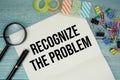 Recognize The Problem text on a paper surrounded by office supplies and magnifying glass on a blue wooden surface Royalty Free Stock Photo