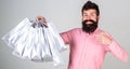 Recommendation concept. Guy shopping and pointing at bags. Man with beard and mustache carries bunch of shopping bags Royalty Free Stock Photo