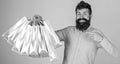 Recommendation concept. Guy shopping and pointing at bags. Man with beard and mustache carries bunch of shopping bags Royalty Free Stock Photo