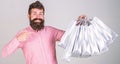 Recommendation concept. Guy shopping and pointing at bags. Man with beard and mustache carries bunch of shopping bags Royalty Free Stock Photo