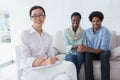 Reconciled couple smiling at camera with therapist