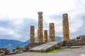 Reconstructed columns of Temple of Apollo at Delphi Greece overlook valley with far-off mountains on foggy day