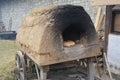 A reconstructed historic wooden cart, wooden wagon with a clay oven on top with baked bread. Baking bread in the old days Royalty Free Stock Photo