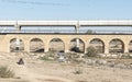 Ancient Bridge and ATV Rider in Front of Modern Train Bridge in Beer Sheva in Israel Royalty Free Stock Photo