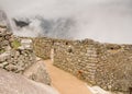 Reconstructed walls of Machu Picchu citadel surrounded by fog, in Urubamba, Peru