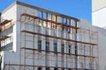 Reconstruction building with external insulation and plaster and with using of scaffolding.