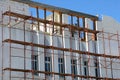 Reconstruction building with external insulation and plaster and with using of scaffolding.