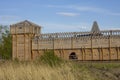 Reconstruction of the high wall of an ancient wooden fortress with a tower Royalty Free Stock Photo