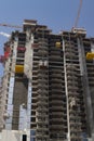 Reconstruction of skyscraper, building repair with cranes on the top of building Royalty Free Stock Photo