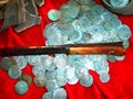 Reconstruction of a treasure from a placer of silver coins of the 17th century and a knife on a red background