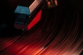 Record player needle reading a vinyl record in red light Royalty Free Stock Photo