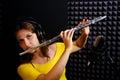 Record wind musical instruments with a professional microphone. Girl flute player in headphones plays in recording studio. Woman Royalty Free Stock Photo