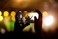 Recording a concert with mobile phone, silhouette of hands with smartphone. Royalty Free Stock Photo