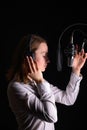 Recording female vocals. Young girl with a microphone and headphones in a recording studio. Recording vocals, blogger, reading