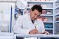 Recording the merchandise. a male pharmacist working in a pharmacy. Royalty Free Stock Photo