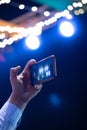 Recording a video of lights in stage with a smartphone in hand Royalty Free Stock Photo