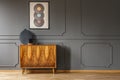 Records on grey wall with molding above wooden cabinet in vintage living room interior. Real photo Royalty Free Stock Photo