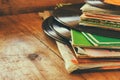 Records stack with record on top over wooden table. vintage filtered Royalty Free Stock Photo