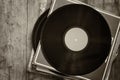 Records stack with record on top over wooden table. vintage filtered Royalty Free Stock Photo