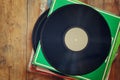 Records stack with record on top over wooden table. vintage filtered Royalty Free Stock Photo