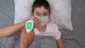 A recovering boy with normal temperature that is shown on a display of infrared contactless thermometer, concept pf healthy child