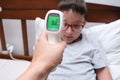 A recovering boy with normal temperature that is shown on a display of infrared contactless thermometer, concept pf