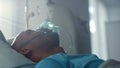 Recovering patient with oxygen mask lying in bed emergency unit ward closeup. Royalty Free Stock Photo