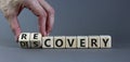Recovery or discovery symbol. Businessman turns wooden cubes, changes a word `discovery` to `recovery`. Beautiful grey backgro