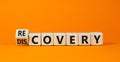 Recovery or discovery symbol. Turned a wooden cube, changed a word `discovery` to `recovery`. Beautiful orange background.