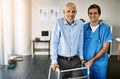 Recovery is easier with the right person by your side. Portrait of a male nurse assisting a senior patient with a walker