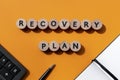 Recovery plan inscription, calculator, pen and notebook on office desk. Business concept. Top view Royalty Free Stock Photo