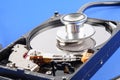 RECOVERY AND REPAIR TECHNOLOGY CONCEPT: Hard Disk Drive HDD with stethoscope isolated on a blue background. Royalty Free Stock Photo