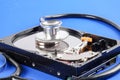 RECOVERY AND REPAIR TECHNOLOGY CONCEPT: Hard Disk Drive HDD with stethoscope isolated on a blue background. Royalty Free Stock Photo