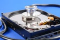 RECOVERY AND REPAIR TECHNOLOGY CONCEPT: Hard Disk Drive HDD with stethoscope isolated on a blue background. Royalty Free Stock Photo