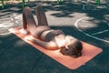 Recovery from the training process. Young woman lying on a yoga mat after a hard workout outdoors Royalty Free Stock Photo