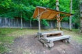 recreation area in a forest, gazebo with a bench and table in the middle of a forest in a clearing Royalty Free Stock Photo