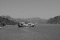 Recreation on the boat near the shore of a mountain. Ship on the water. summer vacation. black and white Royalty Free Stock Photo