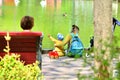 Recreation in a city park. Mother and child relaxing in the park by the pond.