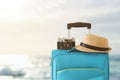 Recreation image of traveler luggage, camera and fedora hat infront of tropical sunset background. holiday and vacation concept