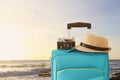 Recreation image of traveler luggage, camera and fedora hat infront of tropical sunset background. holiday and vacation concept