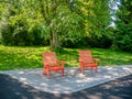Recreational area in a park with two red chairs under the tree Royalty Free Stock Photo