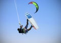 Recreational water sports: kitesurfing. Kiteboarding sportsman jumping high in the sky on windy day. Extreme sports action