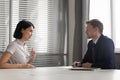 Recruiter listening to young Asian candidate at job interview