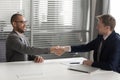 Recruiter shaking hand of African American candidate, successful job interview