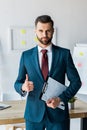 Recruiter standing and holding clipboard with resume letters while showing thumb up