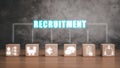 Wooden block on wooden desk with recruitment icon on virtual screen