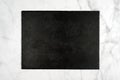 Rectangle black slate stone cutting board, empty signboard on light marble background